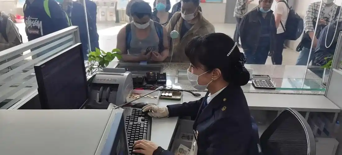 售票员认真有序为旅客发售车票.