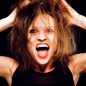 愚蠢的脸年轻的愚蠢的疯狂女孩,头发乱糟糟的,做着愚蠢的脸照片