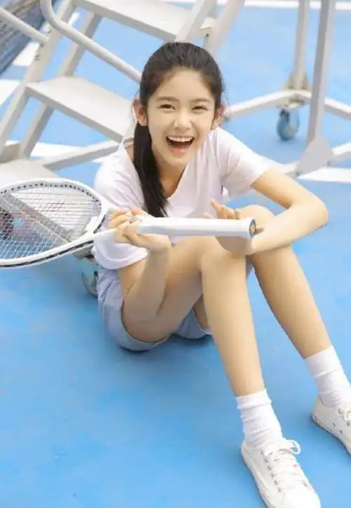 13岁的赵蕴卓一张网球照片,穿着白色短袖,白色球鞋,在学校的网球场里