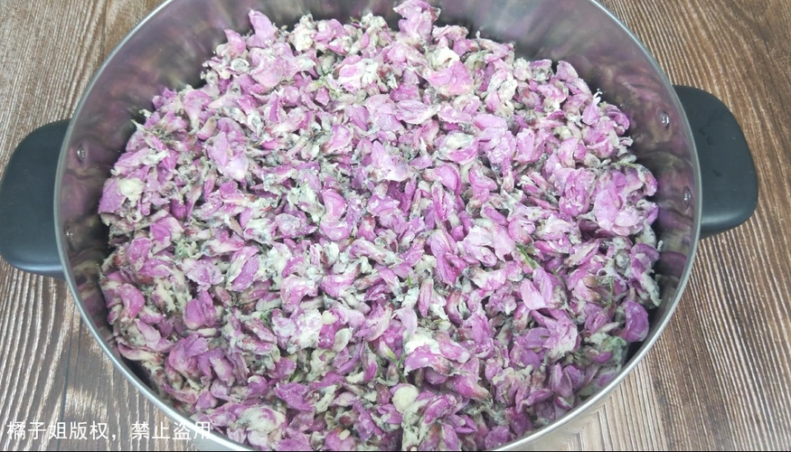 3,趁着蒸洋槐花的时间,剥一头大蒜,加一勺盐,捣成蒜泥,然后加一勺香油