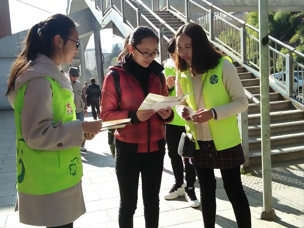 (志愿者向路人分发传单,宣传控烟知识)