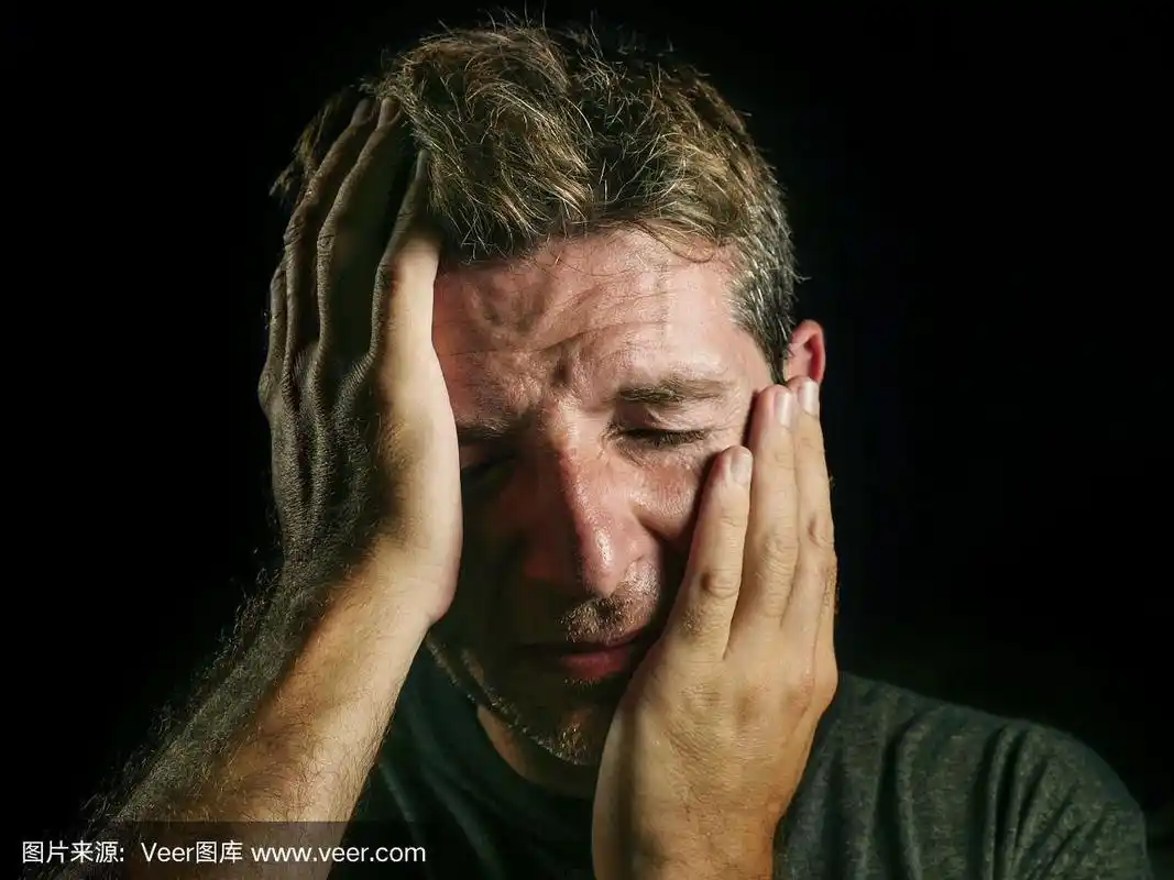 年轻的悲伤和崩溃的男人哭绝望用他的手捂着脸感觉压力和失去痛苦和