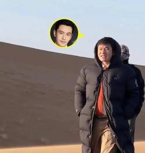 黄晓明身穿黑色羽绒服,背着双肩包在沙漠里行走,整个人表情看起来蛮