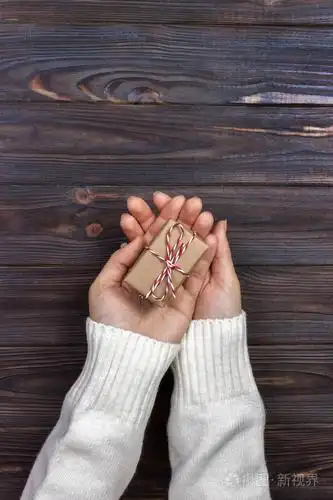 手里捧着工艺纸礼品盒为圣诞节, 新年, 情人节或木制背景,顶视图在纪