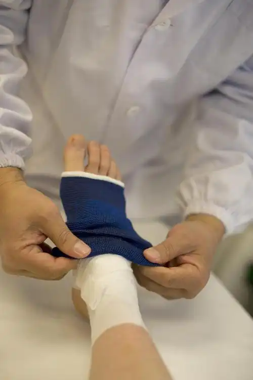 正在包扎的脚,医生包扎女人踝关节
