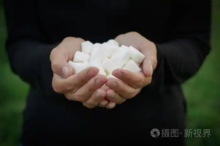 女人手拿白色的糖