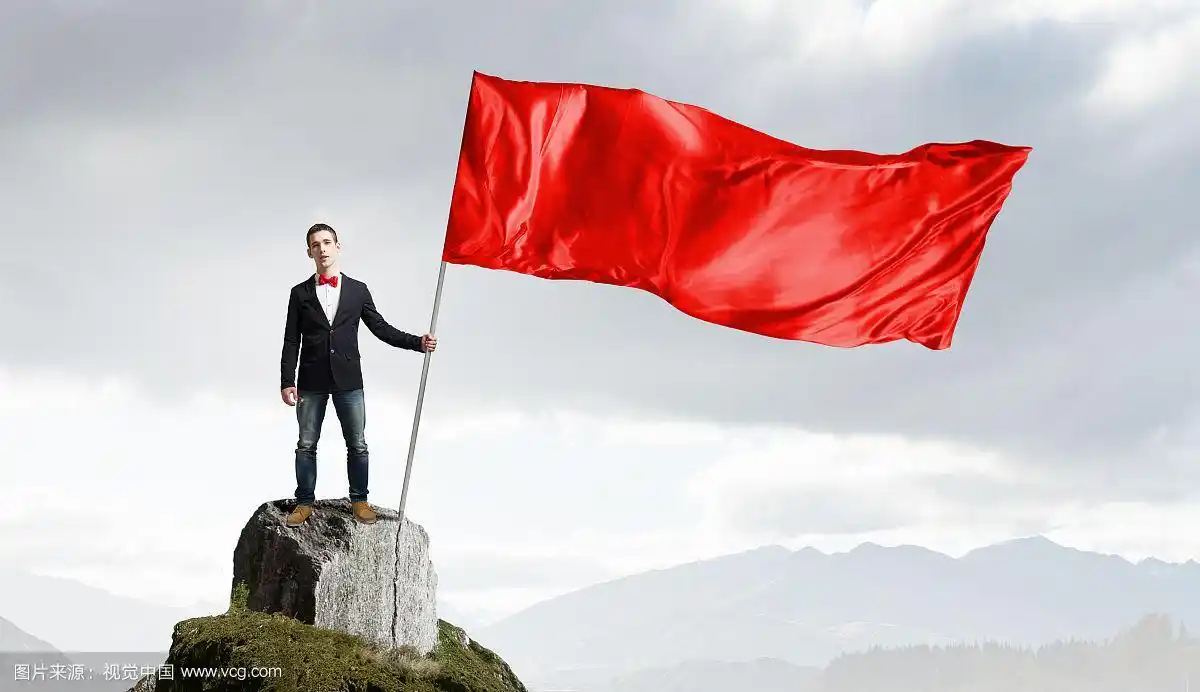 拿着红旗的家伙.打着领结,挥舞着红色旗子的年轻人