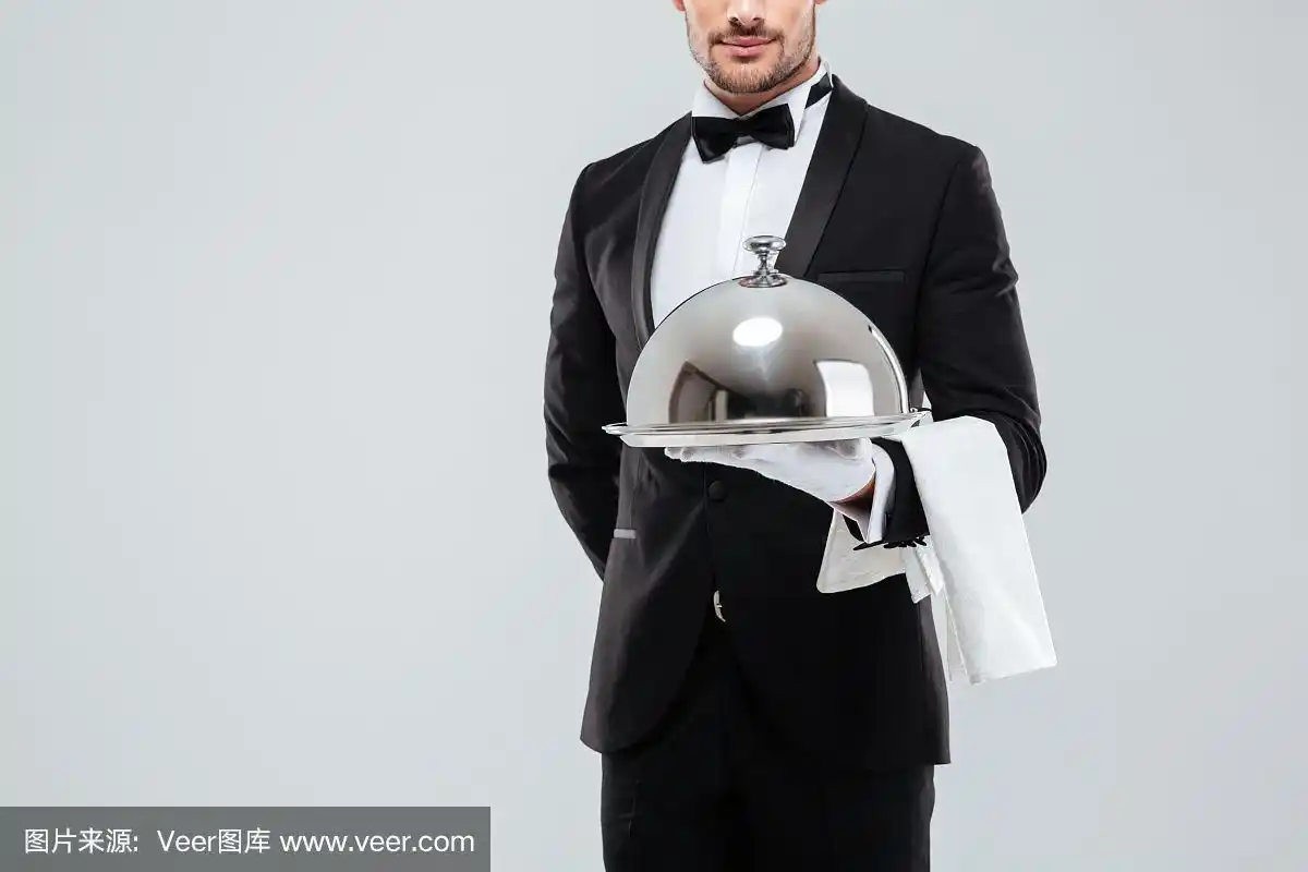 男管家穿着燕尾服,戴着手套,拿着带盖子的银托盘