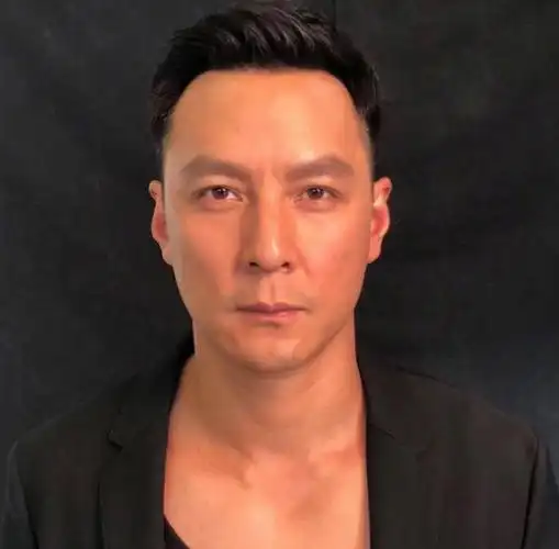 照片中吴彦祖表情严肃,目光平视,标准的证件照姿势