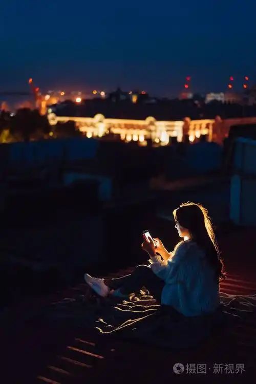 小女孩晚上坐在房子的屋顶上美丽的夜晚