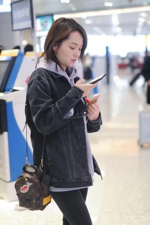 邓莎独自走机场,牛仔外套配"紫薯卫衣"青春又时尚,33美回18岁