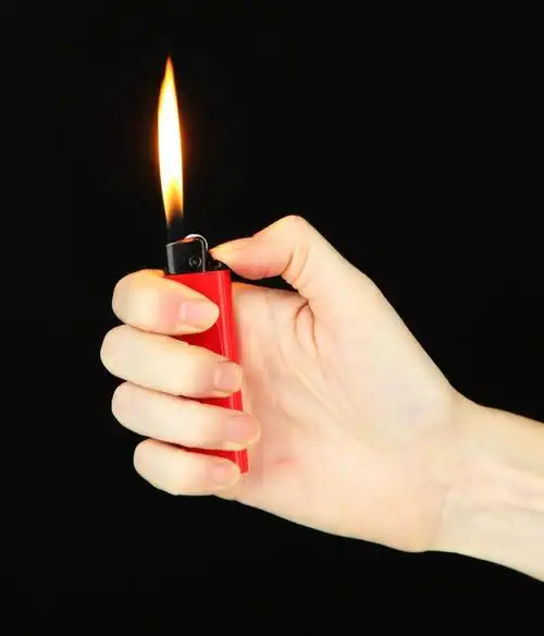 在女性手中燃烧打火机,孤立在黑色