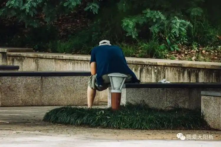 孤独的背影.孤单的大叔,似乎是在刷手机消磨时间!