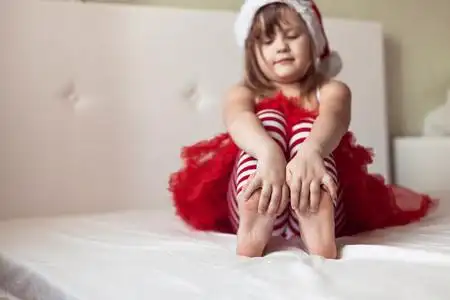 猫到床上一个年轻的昏昏欲睡的女孩休克, 她的眼睛睁大嘴巴, 躺在床上