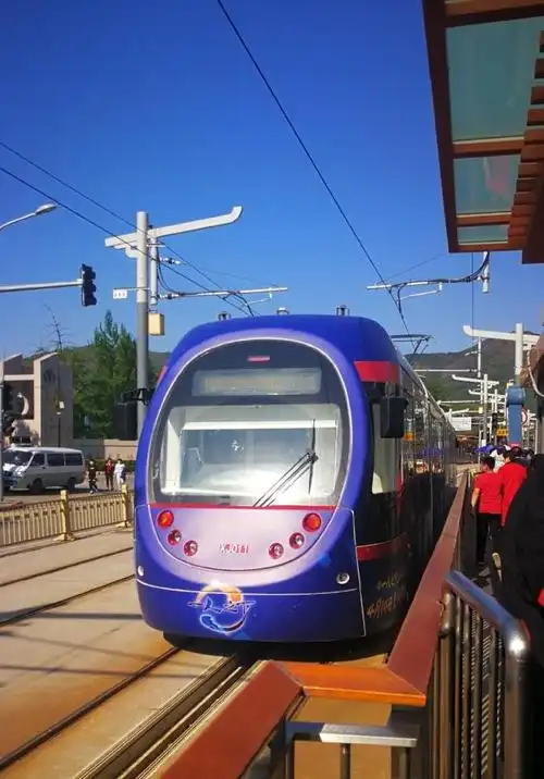 北京地铁西郊线的景观:行驶于蓝天白云之下,轨道上已经绿草成荫