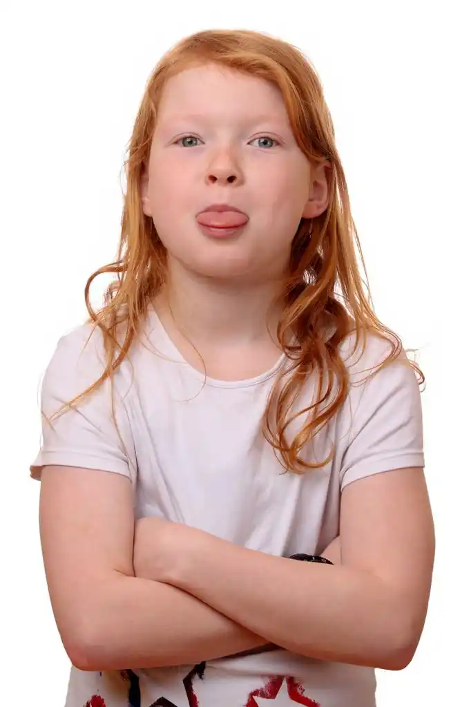 顽皮的小女孩,一个调皮的年轻女孩,在白色背景上的肖像