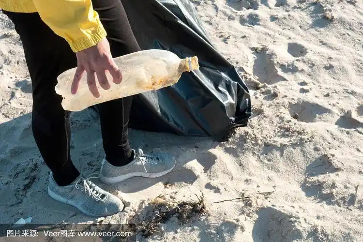 捡垃圾和塑料的女人用垃圾袋清理海滩.