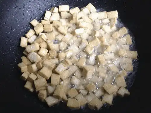 爆炒三丁,白豆腐干洗净切丁,炒锅内加4大勺油烧热, 把豆腐干丁炸至金