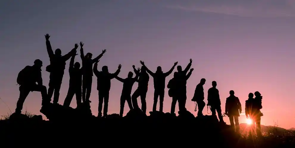 人物团队协作成功登顶的剪影