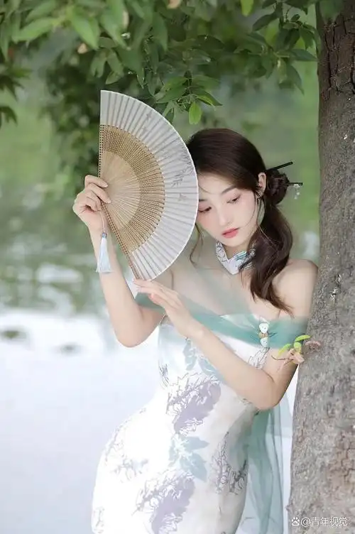 把油纸伞,轻轻地撑开,伞面上的花纹犹如烟雨中的江南风情,温柔而细腻