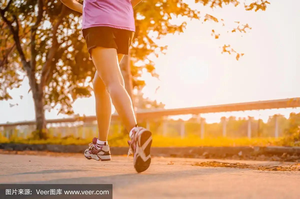 积极健康的跑步者户外慢跑.在晨曦中在公园慢跑的女人