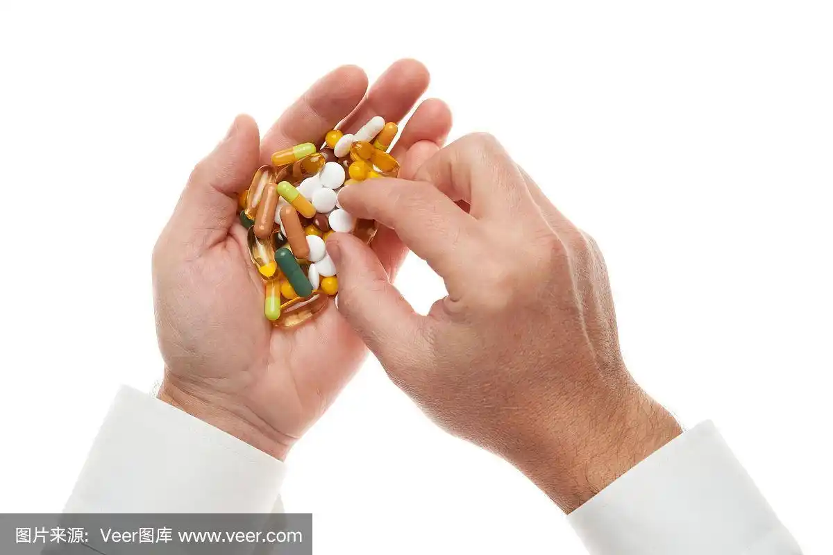 男子手中拿着一把药丸,片剂,维生素,药物,胶囊孤立在白色背景上.