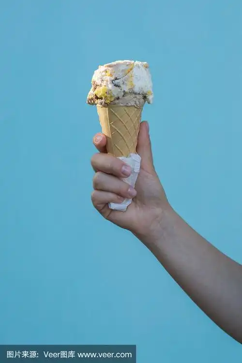 天蓝色背景下的女孩手里拿着甜筒冰淇淋