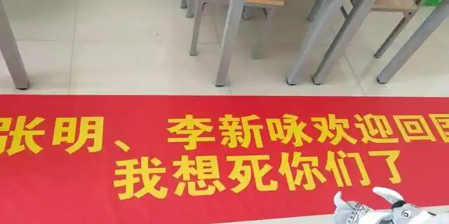 他拉着横幅来接机啦