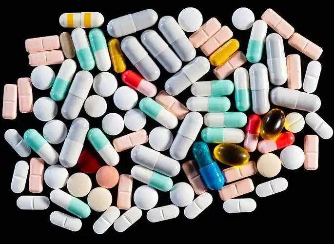 在写字板上排列着各种白色的药丸和胶囊