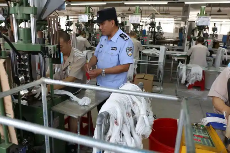 老王仔细查看当天罪犯劳动情况