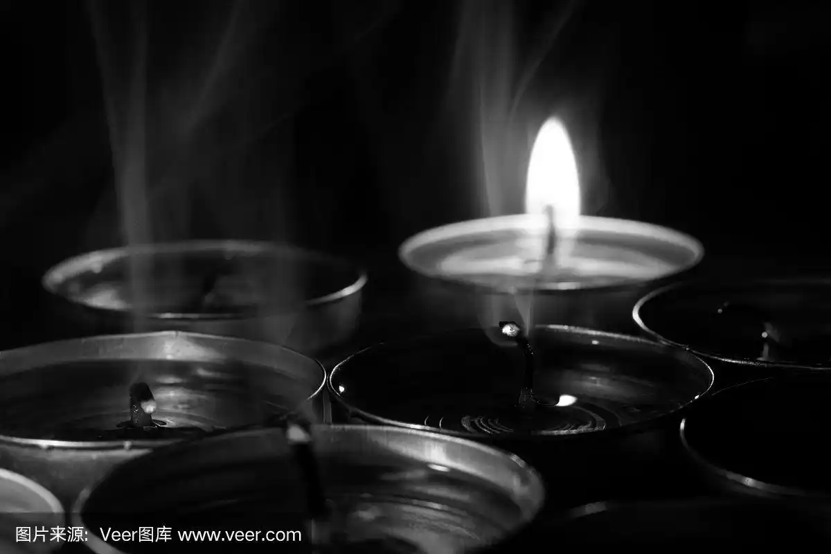 黑色背景中燃烧着的蜡烛.黑白照片.