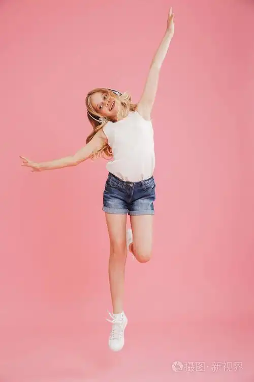 全长图像快乐的小女孩8-10 在休闲服装跳舞和听音乐与无线耳机在头上