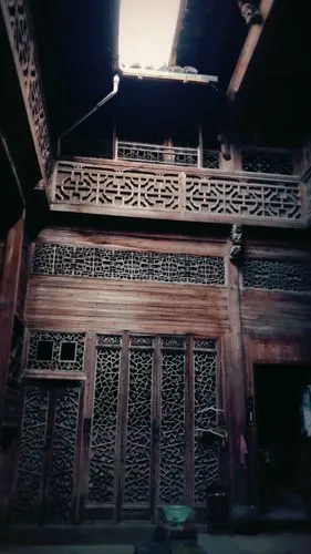 沿着黑窄的木质楼梯吱丫丫地上去,是浓重木雕韵味的环形阁楼.