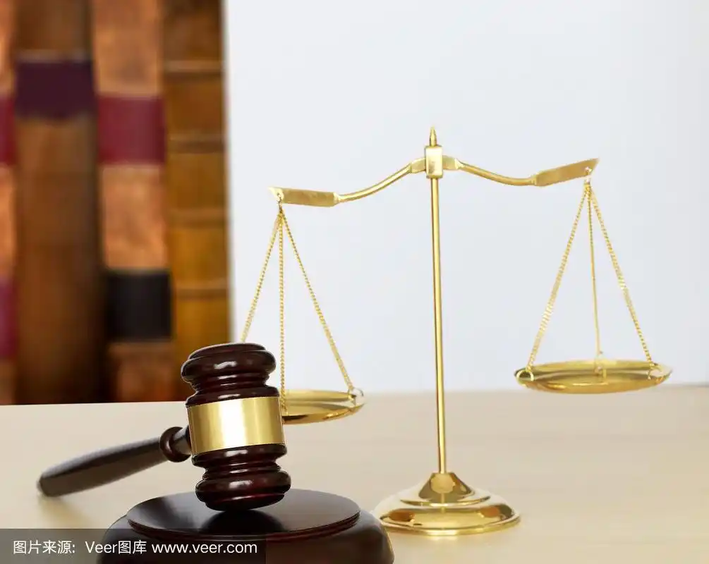 法官用木槌将正义和法律的天平放在桌面上