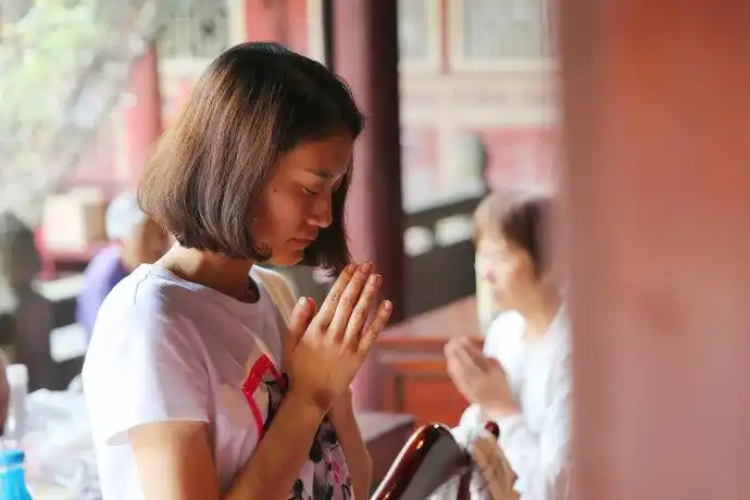朝拜随行者美国女孩倬莹在合十感恩,祈祷