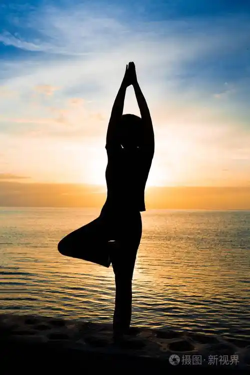 日落或日出时在b座做瑜伽的女人的剪影