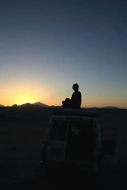 在撒哈拉沙漠中,坐上车顶看着太阳缓缓西落.