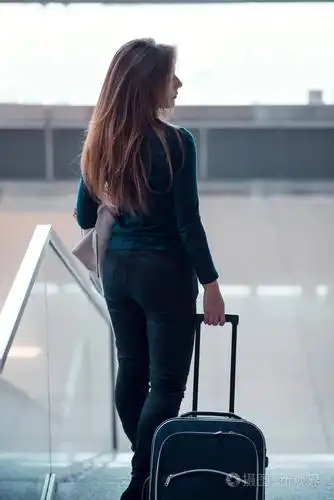 行李箱自动扶梯向下移动的女人