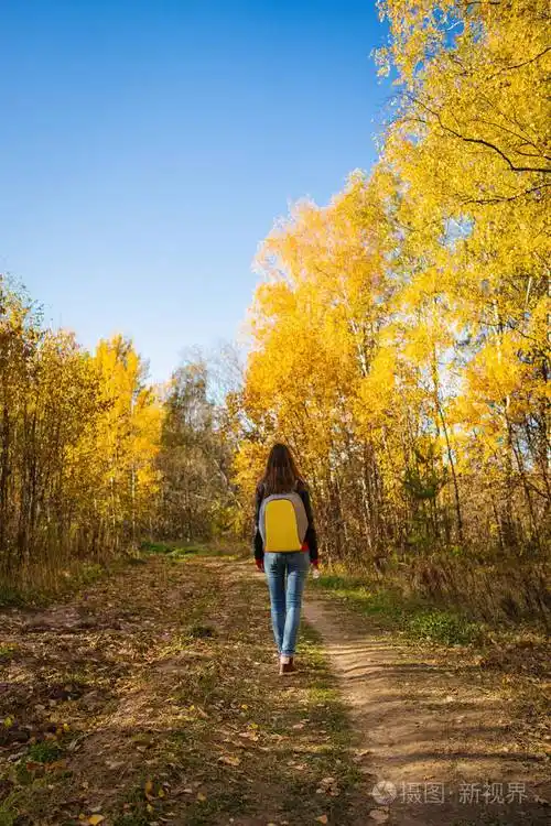 一个背着背包的年轻女子独自在秋天散步照片-正版商用图片2oh26w-摄图
