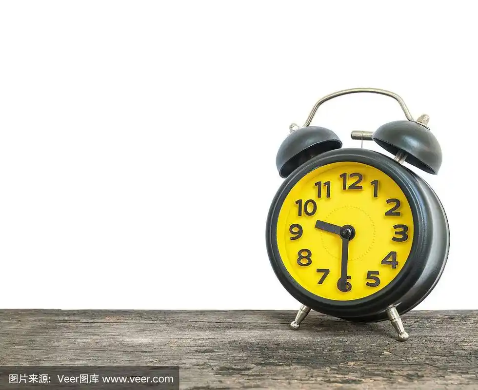 特写黑色和黄色闹钟装饰显示九点半或上午九点半在旧的棕色木桌孤立的