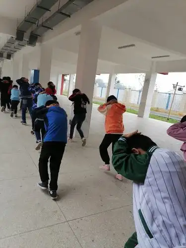 两边消防安全出入口的学生依次有序的向操场空旷地段跑去.