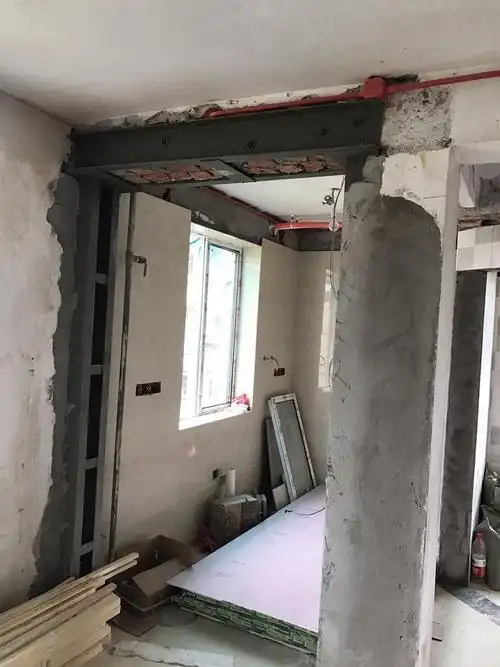 客厅与厨房间的墙被整面敲掉了,靠两边孤零零的两根工字钢撑着,而且