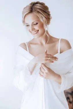 金发碧眼的美丽微笑的女人轻盈身材自然发型内饰白色内衣的快乐金发