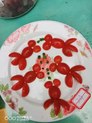 好看的圣女果金鱼拼盘,5只小金鱼正在各自吃着它们的食物,不争不抢