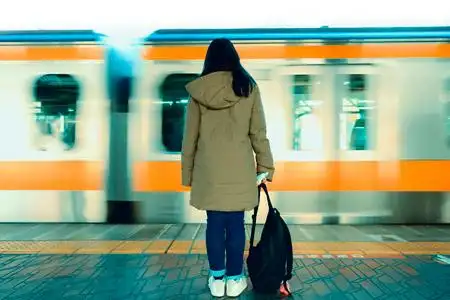 女孩站在高速火车站等火车照片