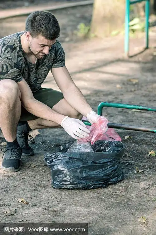 一名志愿者穿着衣服在公园里捡垃圾和塑料垃圾.