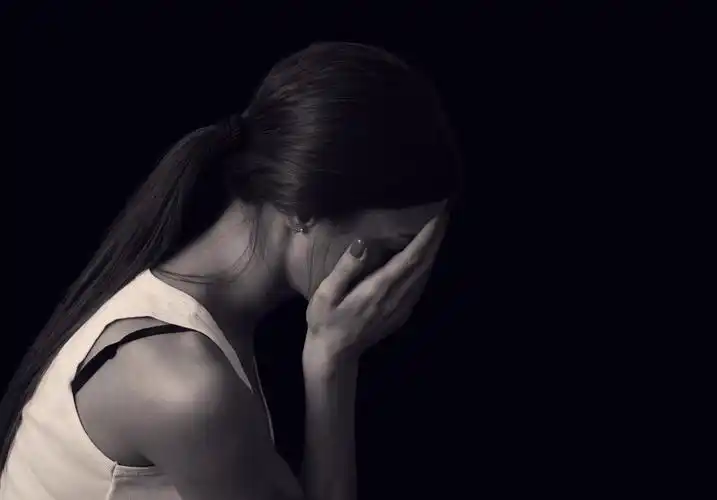 年轻女性表达在黑色背景上的痛苦和悲伤