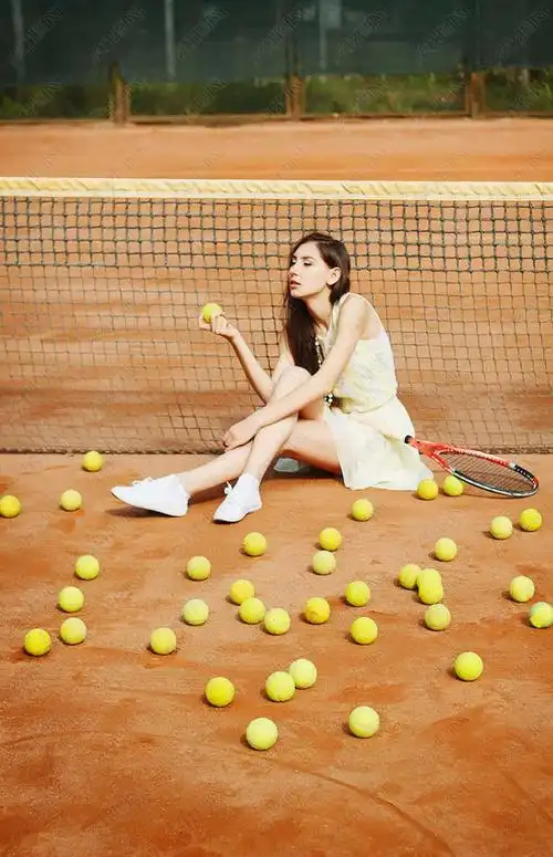 年轻漂亮的黑发女子在球场上打网球的照片