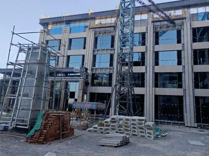 西立面2轴至13轴挑檐铝板安装完成,石材安装完成60%