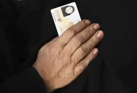 新宪法第一轮投票期间,一位妇女手持身份证进入投票站.